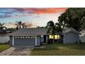 Blue house with a two-car garage and landscaping at dusk at 5125 Formby Dr, Orlando, FL 32812