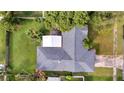 House with gray roof and a detached structure, surrounded by lush green landscaping at 5125 Formby Dr, Orlando, FL 32812