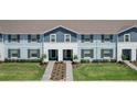 Two-story townhomes with light blue and gray siding, paved walkways, and green lawns at 617 Jasmine Ln, Davenport, FL 33897