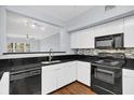 Modern kitchen with black appliances, white cabinets, and dark granite countertops at 204 E South St # 1055, Orlando, FL 32801