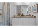 Double vanity bathroom with granite countertops, white cabinets, and a large mirror at 4185 Singing Mockingbird Blvd, Bartow, FL 33830