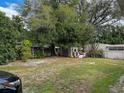 Large backyard with mature trees, shed, and grassy area at 2109 Morning Dr, Orlando, FL 32809