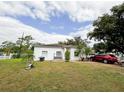 Front yard view of a white single-story house with a red car parked nearby at 2109 Morning Dr, Orlando, FL 32809