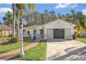 House exterior with a landscaped yard, walkway, and two-car garage at 2460 Oak Mill Dr, Kissimmee, FL 34744
