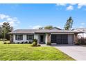 Newly renovated home with gray exterior and a well-manicured lawn at 26603 W Cove Dr, Tavares, FL 32778