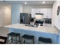 Modern kitchen with stainless steel appliances and breakfast bar at 310 Gardenia Ct, Poinciana, FL 34759