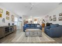 Open living room with gray couches, a coffee table, and wood-look floors at 4694 Monica St, The Villages, FL 32163