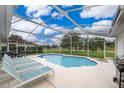 Relaxing pool area with lounge chairs and screened enclosure at 577 Sunridge Woods Blvd, Davenport, FL 33837