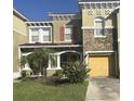 Two-story townhome with a yellow garage door and landscaping at 3006 Seaview Castle Dr, Kissimmee, FL 34746