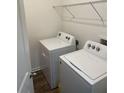 Bright laundry room with Whirlpool washer and dryer, and ample shelving at 16344 Blooming Cherry Dr, Groveland, FL 34736