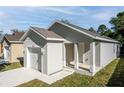 Newly built home with gray siding, a white garage door, and a small front porch at 1991 Hollywood Ave, Eustis, FL 32726