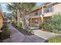 Condo building exterior showcasing lush landscaping and walkway at 2711 Emerald Lake Ct, Kissimmee, FL 34744