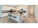 Modern kitchen with island, white cabinets, and grey countertops at 729 Hitch Loop, St Cloud, FL 34772