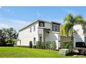 Modern home with gray siding, stone accents, and lush landscaping at 836 Desert Mountain Ct, Reunion, FL 34747