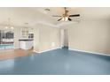 Open living room with light walls, blue floor, and view of kitchen at 162 Pecan Dr, Ocala, FL 34472