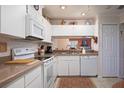 White kitchen with granite counters, ample cabinets, and a view to the living area at 3 Escondido Cir # 18, Altamonte Springs, FL 32701