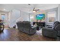 Living room with dark leather reclining sofas, large TV, and wood-look floors at 5027 Lake Hamlin Trl, Winter Garden, FL 34787