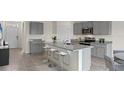 Modern kitchen with gray cabinets, granite countertops, and an island with seating at 2842 Moulin Rd, Davenport, FL 33837