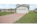 Brick driveway leads to a two-car garage of a two story house at 3817 Giorgio Dr, Winter Haven, FL 33884