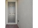 Gray front door entryway with brick paved flooring at 4702 Jasmine Cir, Leesburg, FL 34748