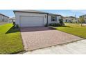 Brick paved driveway and front yard of a single-Gathering home at 4702 Jasmine Cir, Leesburg, FL 34748