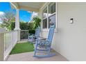 Relaxing front porch with blue rocking chairs and artificial turf at 1018 Wilks Ave, Belle Isle, FL 32809