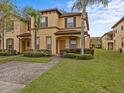 Two-story townhome with brick paver driveway and palm trees at 408 Miramar Avenue, Davenport, FL 33897