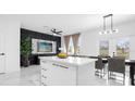 Modern kitchen and dining area with white cabinetry, marble floors, and a large island at 397 Madison Dr, Davenport, FL 33837