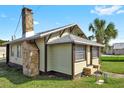 Side view of a charming bungalow with stone chimney and palm trees at 5305 S Ridgewood Ave, Port Orange, FL 32127