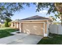 Attached garage with driveway and landscaping at 13303 Pinyon Dr, Clermont, FL 34711