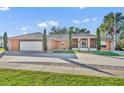 Single-story home with attached garage, landscaping, and a large driveway at 2505 Hillside Ave, Orange City, FL 32763