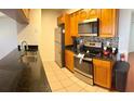 Modern kitchen with granite countertops, stainless steel appliances, and wood cabinets at 2749 N Poinciana Blvd # 16, Kissimmee, FL 34746