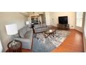 Bright living room featuring hardwood floors, comfortable sofas, and a large TV at 2749 N Poinciana Blvd # 16, Kissimmee, FL 34746