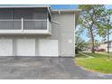 Condo building exterior showcasing three attached garages and a balcony at 4406 Shadow Crest Pl # 4, Orlando, FL 32811