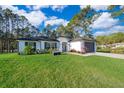 White house with gray garage door, paved driveway, and green lawn at 41755 Viola Way, Eustis, FL 32736