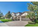 Two-story house with a paver driveway and lush landscaping at 8441 Chilton Dr, Orlando, FL 32836