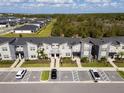 Aerial view of townhouses community with parking and green areas at 8987 Cabot Cliffs Dr, Davenport, FL 33896