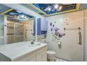 Main bathroom with shower, vanity, and decorative floral wall art at 1716 Sprucewood Ln, Orlando, FL 32818