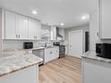 Renovated kitchen, featuring white cabinets, granite countertops, and stainless steel appliances at 4851 Foxrun Cir, Lakeland, FL 33813