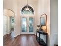 Bright and airy foyer with hardwood floors and a decorative mirror at 8019 Arcadian Ct, Mount Dora, FL 32757