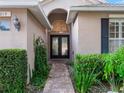 Brick walkway leads to a double-door entry with decorative glass at 8019 Arcadian Ct, Mount Dora, FL 32757