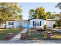 White mid-century modern home with teal door, black shutters, and landscaped yard at 1311 Hartley Ave, Deltona, FL 32725