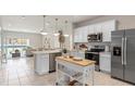 Open concept kitchen with white cabinets, stainless steel appliances, and kitchen island at 2570 Winsome Way, Davenport, FL 33896