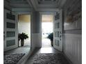 Bright entryway with two white doors, mirror, and plants at 9859 Winnington St, Orlando, FL 32832