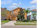 Two-story house with orange exterior, attached garage, and manicured lawn at 2948 Banana Palm Dr, Kissimmee, FL 34747