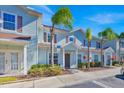 Two-story light blue townhome with palm trees and parking spaces at 3205 Gold Ln, Kissimmee, FL 34747