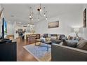 Open living area with gray sofa, wood floors, and unique lighting fixture at 3205 Gold Ln, Kissimmee, FL 34747