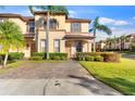 Two-story townhome with brick paver driveway and walkway, lush landscaping at 602 La Mirage St, Davenport, FL 33897