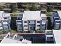 Modern townhome community with white roofs, and a tree-lined street at 7760 Sandy Ridge Dr # 222, Kissimmee, FL 34747