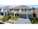 Two-story house with a two-car garage and landscaped yard at 2477 Shanti Dr, Kissimmee, FL 34746